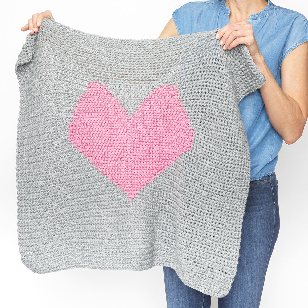 This easy baby blanket is fun to work on and full of love. This free crochet pattern would make a sweet gift for a family friend or even donate one to the local hospital. #CrochetBabyBlanket #EasyCrochetBabyBlanket #BabyBlanketPattern