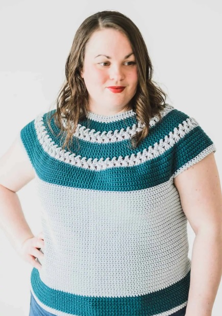 a woman wearing a top down crochet tee with braids