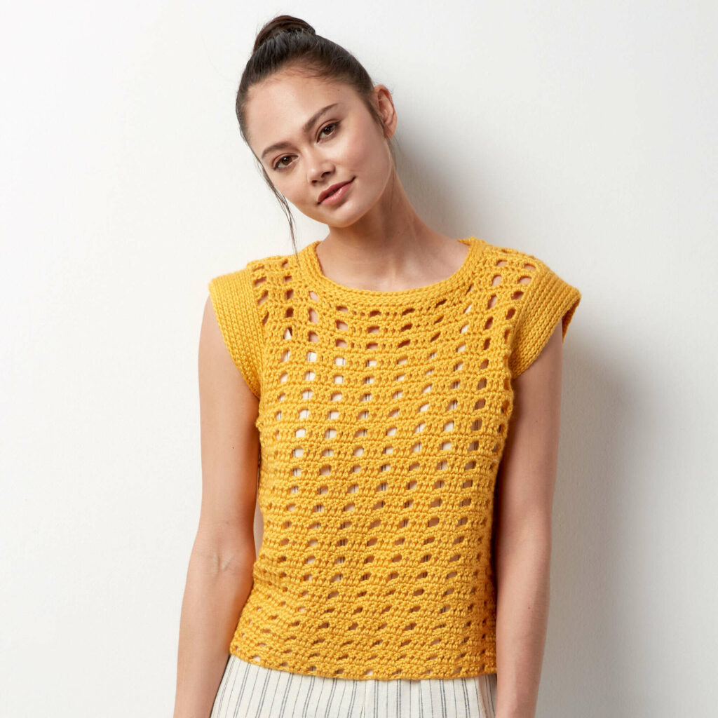 a girl wearing a yellow crochet top