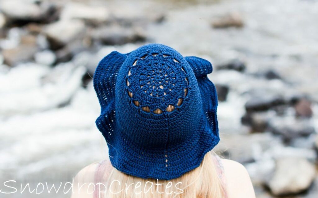 a girl wearing a blue crochet sun hat