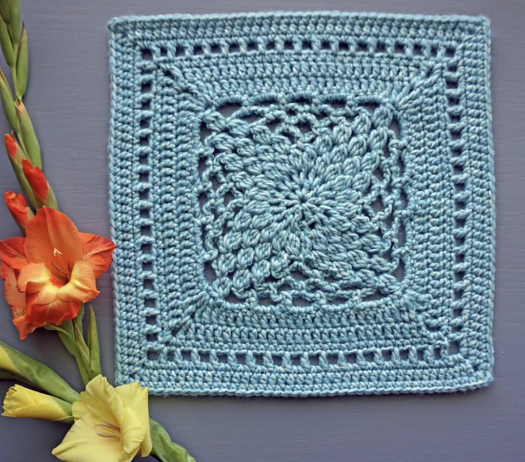 Crochet Origami Flower Square next to a flower