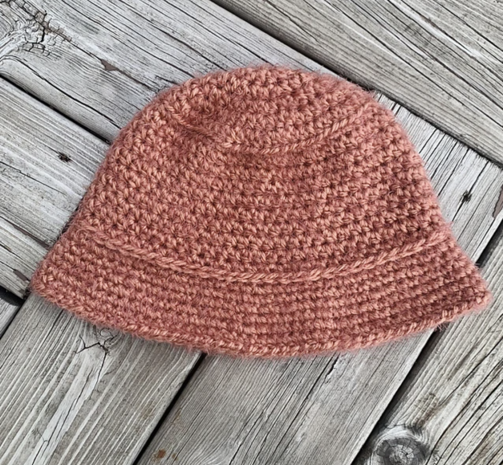 The Willow Crochet Bucket Hat on a wooden surface