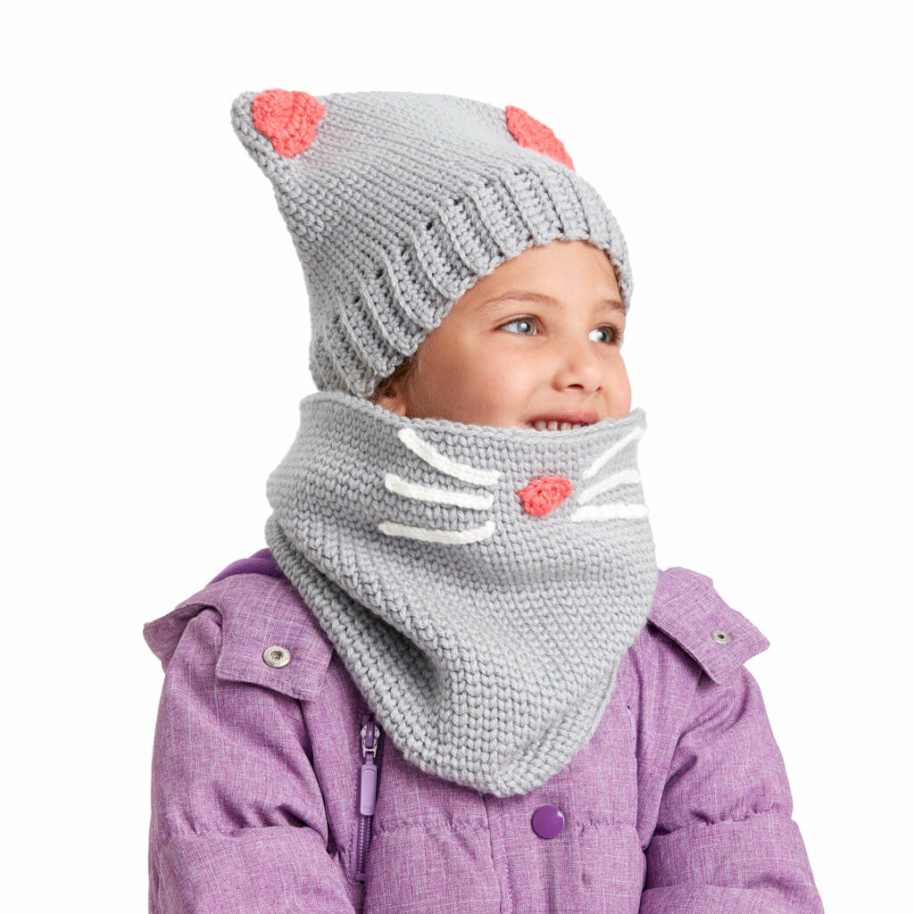 a girl wearing a kitty cat crochet hat and cowl