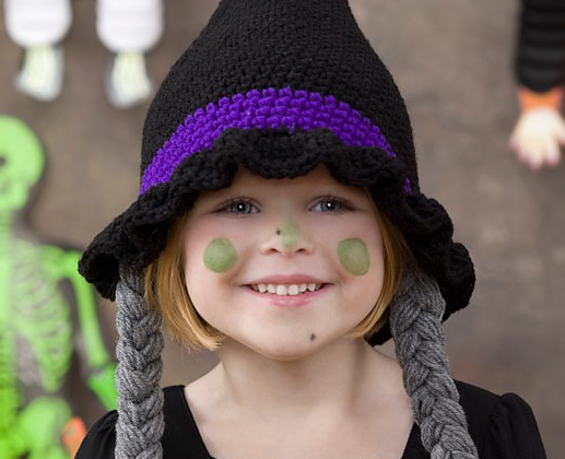 a girl wearing a crochet witch hat