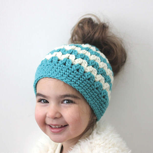 a girl wearing a messy bun crochet hat