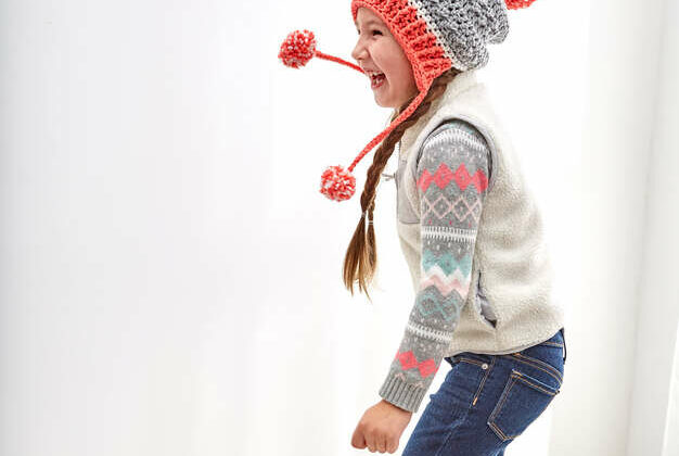 a child wearing a crochet hat with pom pom