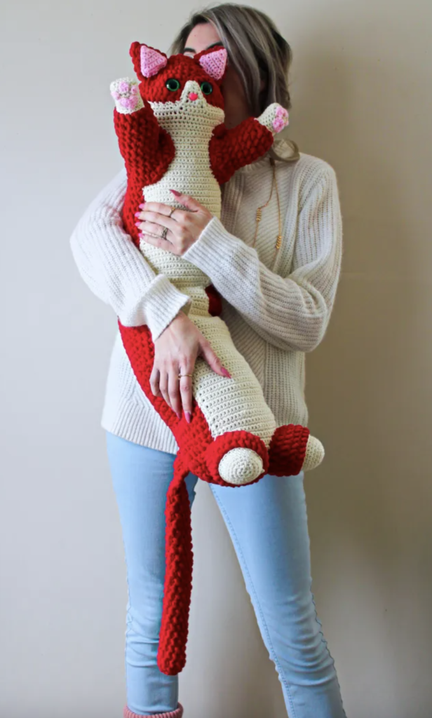 woman holding valentine crochet cat pillow