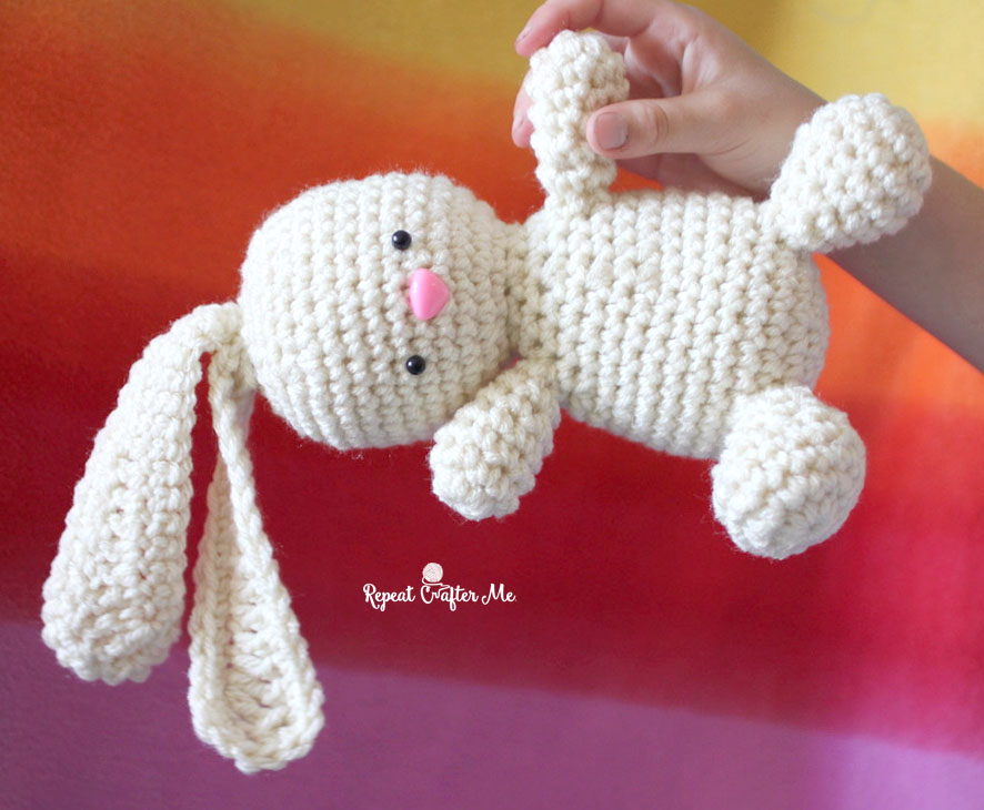 a person holding a crochet bunny by repeat crafter me
